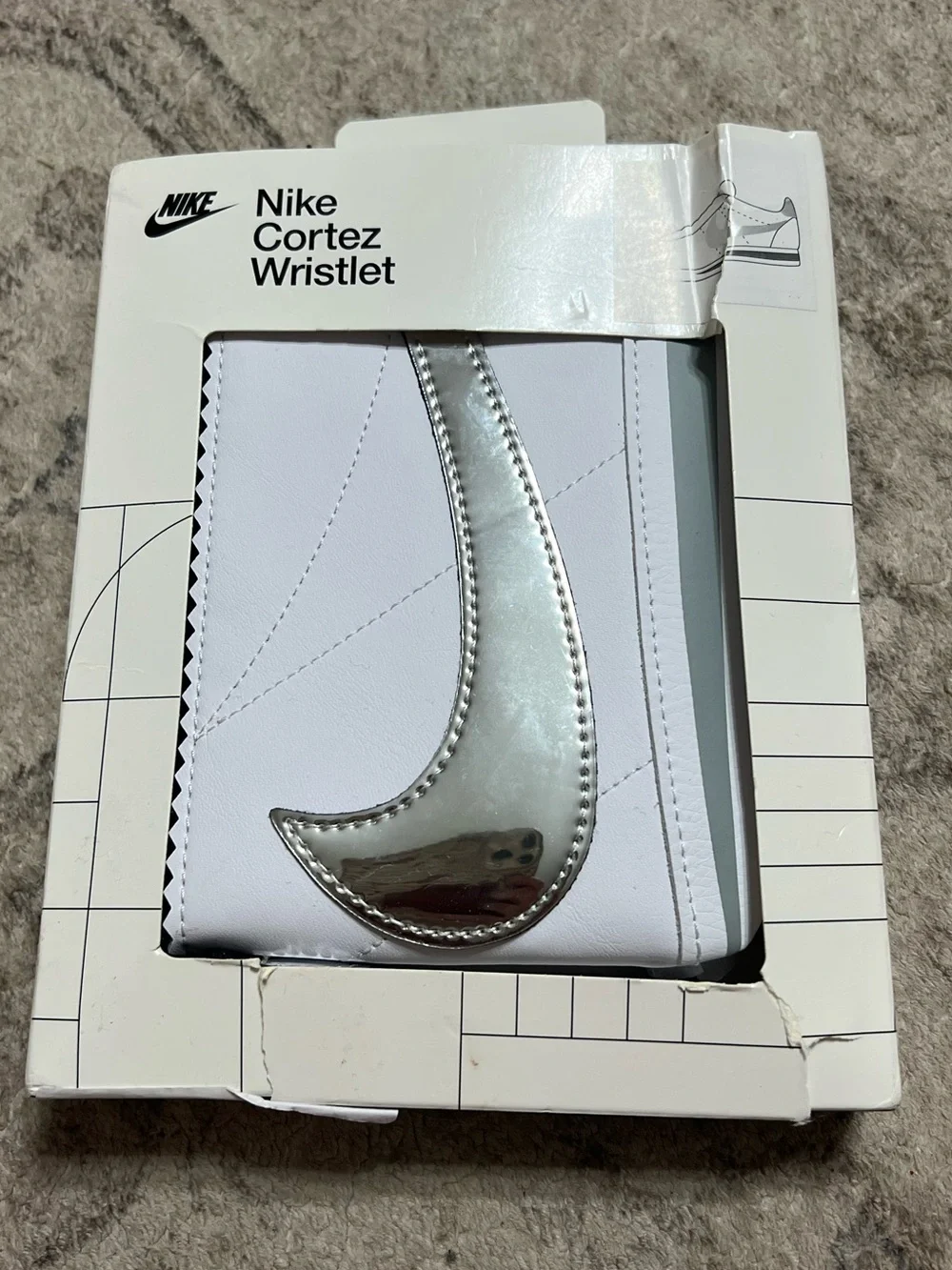 The Nike Icon Cortez Wristlet in white and silver
